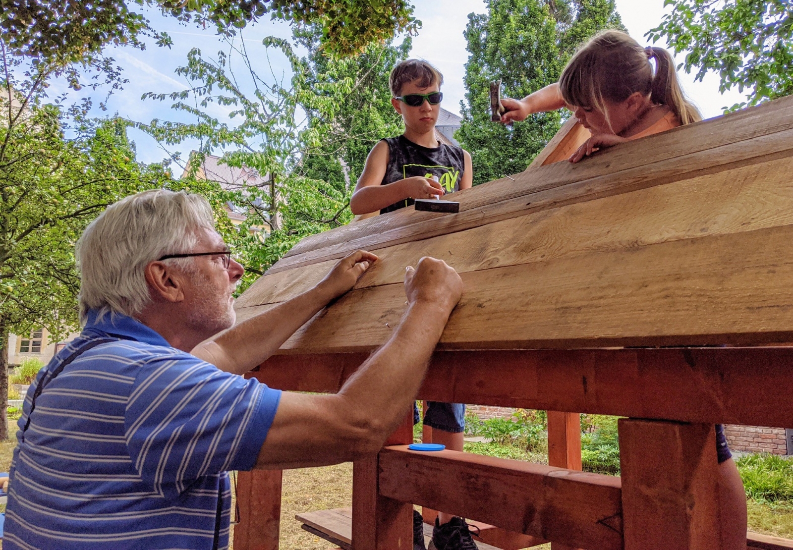 Zwei Kinder bauen unter Anleitung ein Fachwerkhaus