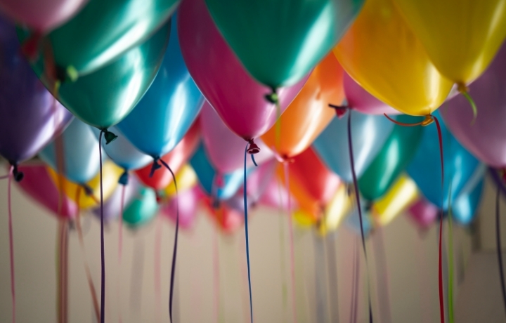 Viele bunte Ballons hängen an der Decke - die Schnüren hängen runter.