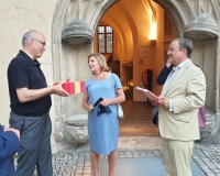 Dr. Rhein überreicht dem Ehepaar Laschet die Geschenke vor dem Katharinen-Portal